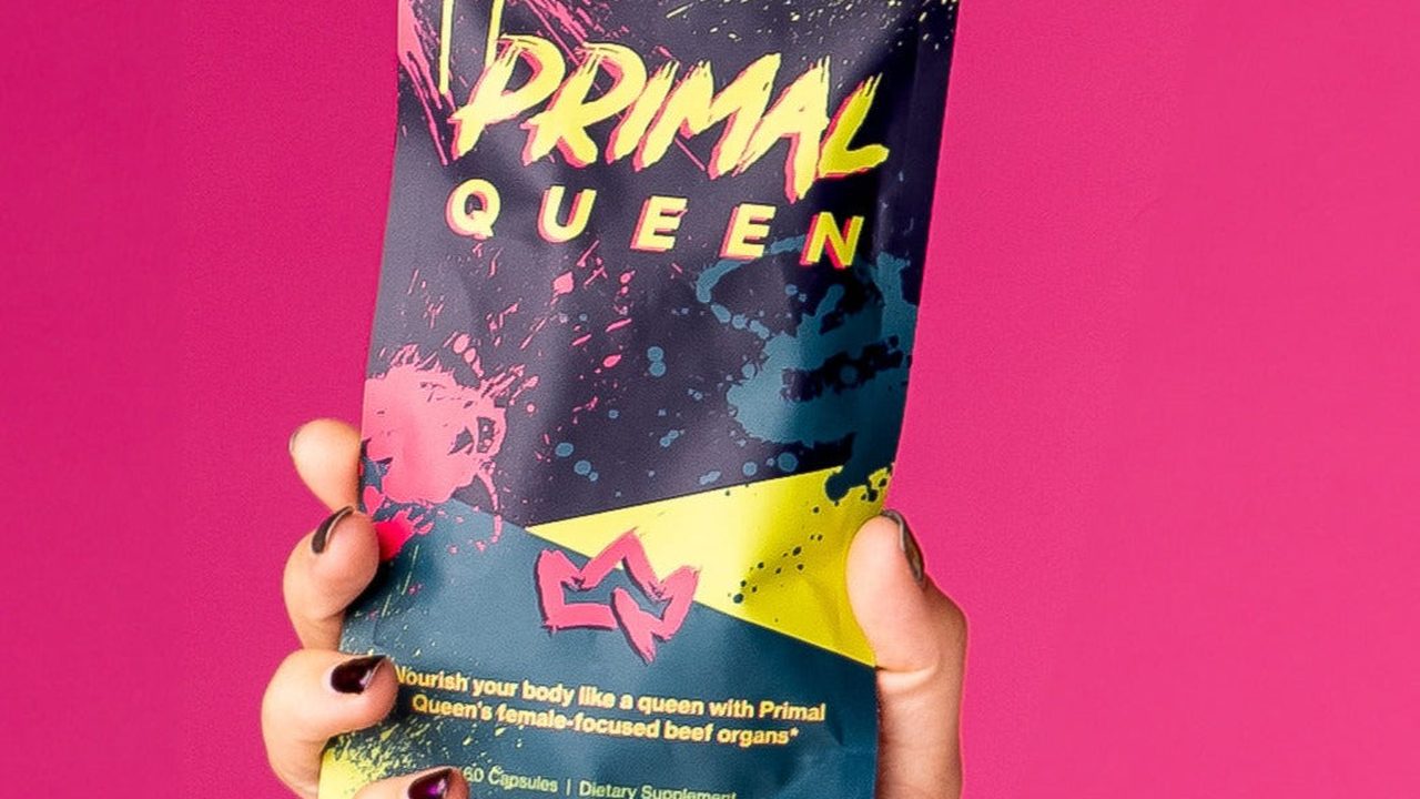 A hand holding a pouch of Primal Queen beef organ supplement