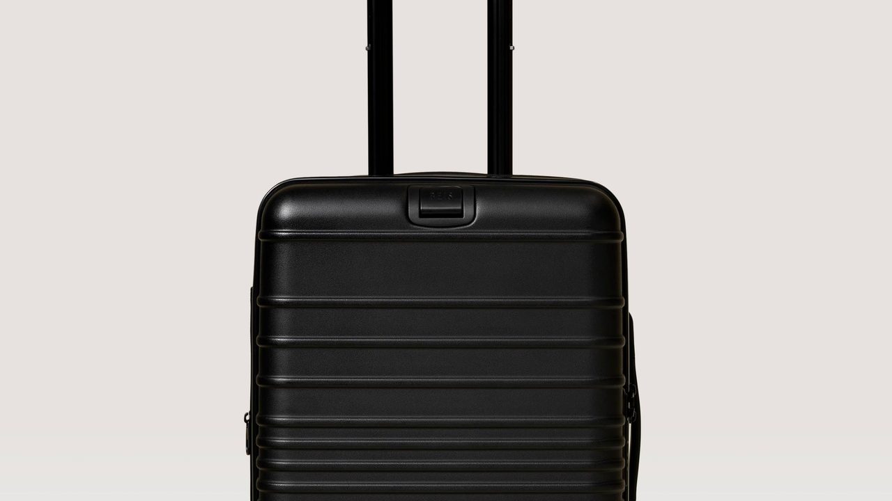 A black BEIS carry-on roller suitcase